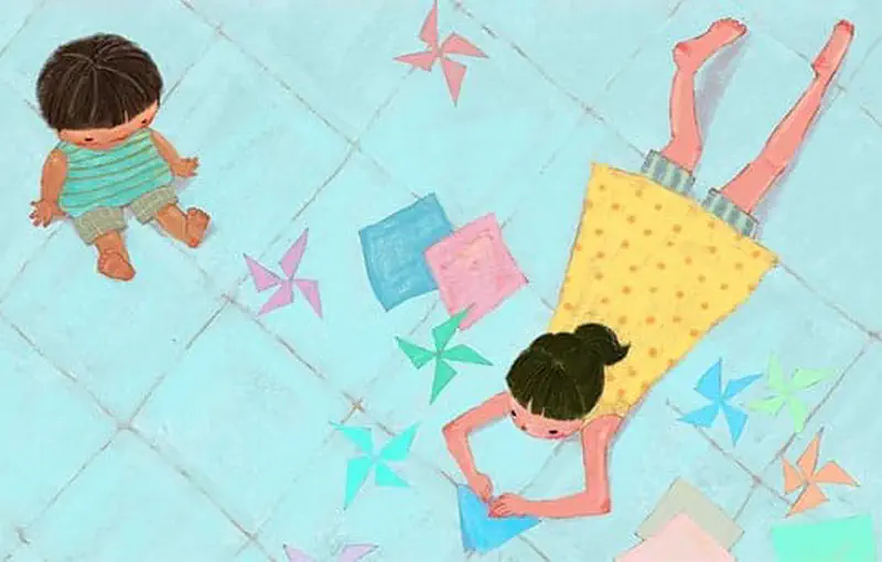 Overhead view of boy sitting sadly while sister makes paper pinwheels on blue floor