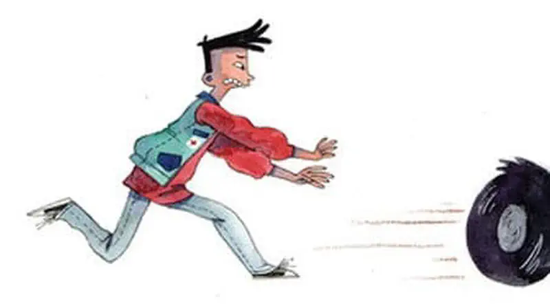 Man in red jacket running and chasing after a loose tire rolling away.