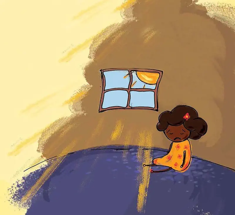 A sad girl with curly brown hair in an orange dress sits alone in a room with sunlight streaming through a window.