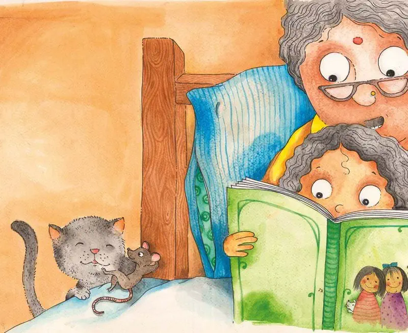 Grandmother with glasses reads a green storybook to a curly-haired child in bed while a gray cat plays with a mouse nearby.