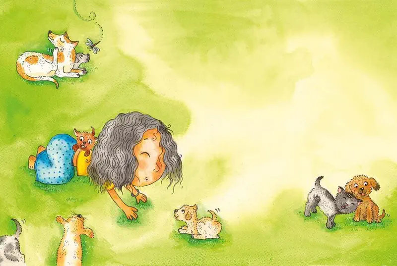 Girl with curly hair crawls on green grass playing with several puppies and dogs of different colors while a dragonfly hovers above.
