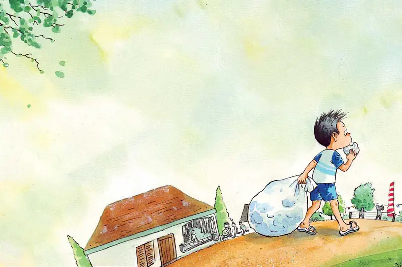 Boy in blue striped shirt walks eating a cracker while carrying a large bag past houses decorated for Indonesian Independence Day.