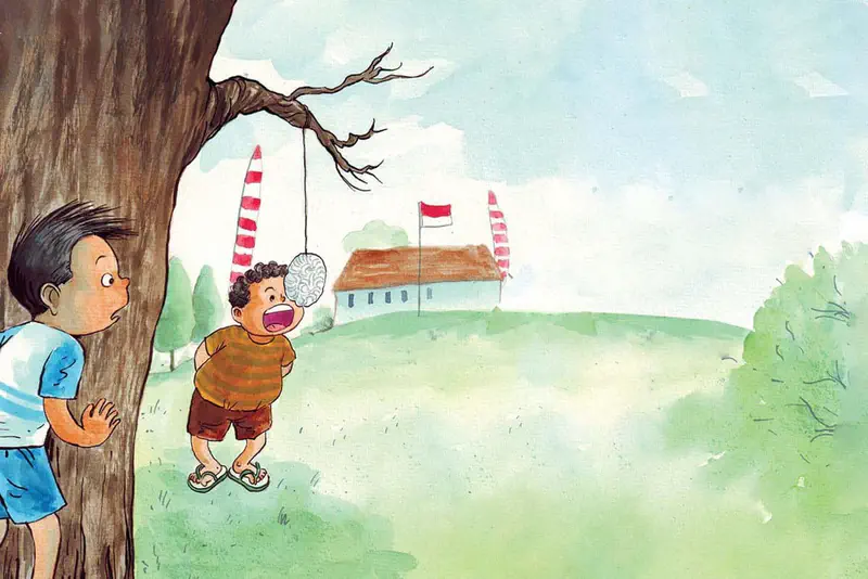 Slim boy watches a chubby boy in striped shirt excitedly eating a hanging kerupuk cracker with a school and Indonesian flags behind them.