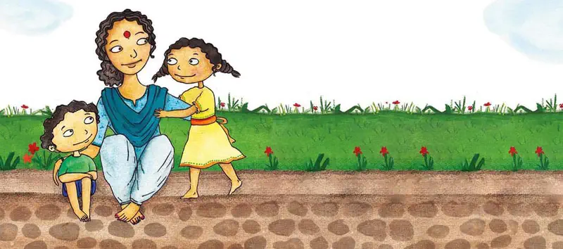 A happy mother in blue kneels with her two children by a garden path with red flowers. The family enjoys time together outdoors.