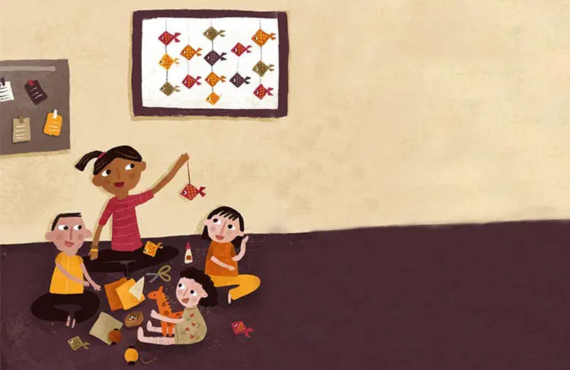 Children sitting on floor doing crafts with fish artwork on wall, girl holding paper fish.