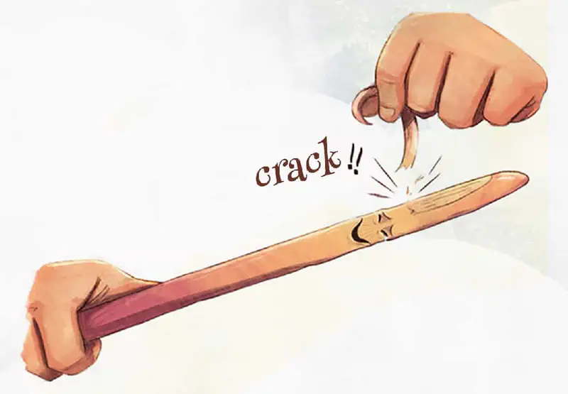 Two hands bending wooden wand with face until it cracks in the middle.