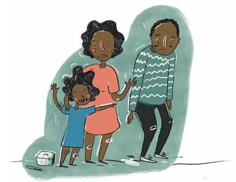 Upset family stands together looking disappointed with the crying daughter hugging her mother while father looks sad.