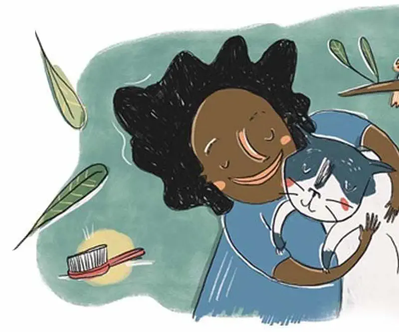 Happy girl with curly hair hugs and cuddles her beloved gray and white cat surrounded by leaves and a brush.