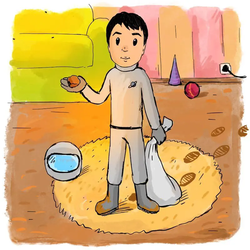 A boy astronaut holds a rock and bag while standing on a yellow rug in a room with toys.