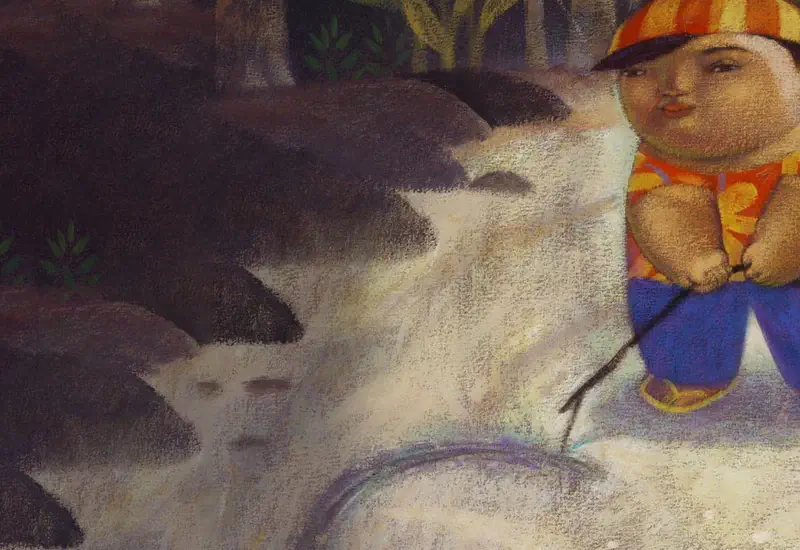 A boy in an orange striped shirt and cap crouches by a rocky stream, poking the water with a stick in a forested setting.