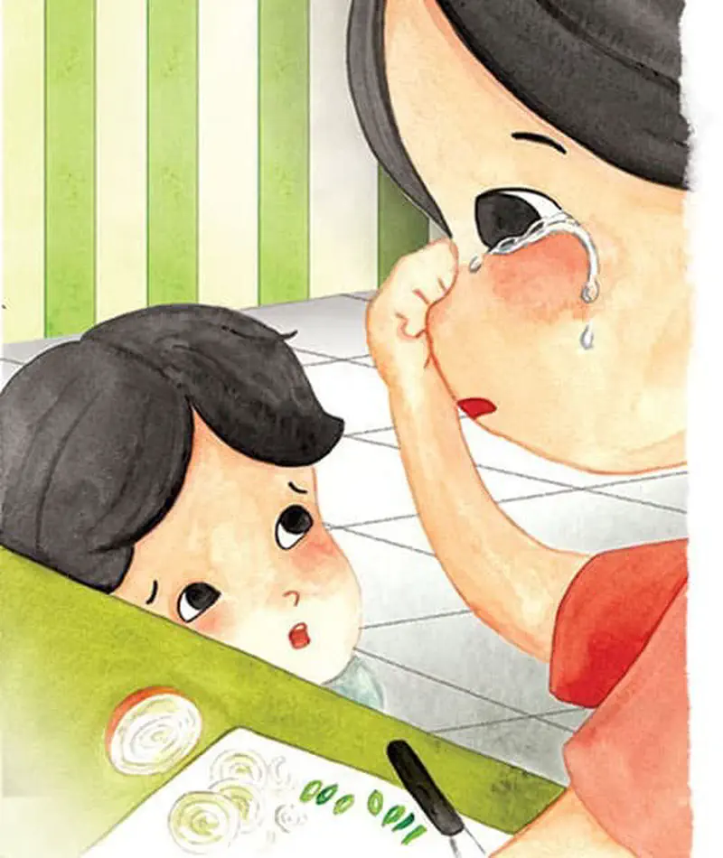 A close-up of a girl crying while cutting onions as a young boy watches with concern from across the kitchen counter.