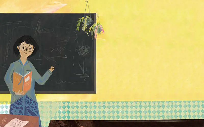 A smiling teacher with round glasses holds an orange book while teaching near a blackboard with chalk drawings and hanging plants.