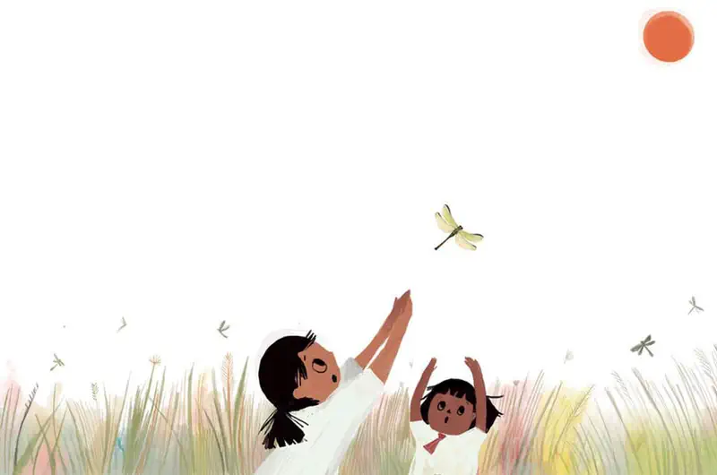 Two girls reach up trying to catch a dragonfly flying above them in a field of tall grass under an orange sun.