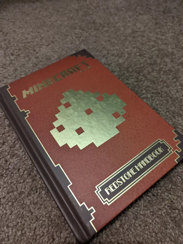 The brown and gold cover of a Redstone Handbook, Minecraft guidebook